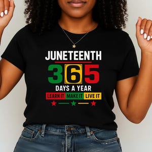 May include: Black t-shirt with the text "Juneteenth 365 Days a Year Learn It Make It Live It" in green, yellow, and red. The text is surrounded by a white border.