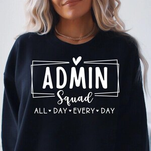 May include: Black sweatshirt with the text "ADMIN Squad" inside a white rectangular frame, with the words "ALL DAY EVERY DAY" below. A small white heart is above the word "ADMIN".