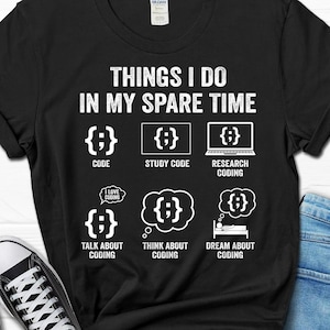 May include: Black t-shirt with white text that reads "Things I do in my spare time". The text is surrounded by six icons that depict different stages of coding. The icons include "Code", "Study Code", "Research Coding", "Talk About Coding", "Think About Coding", and "Dream About Coding".