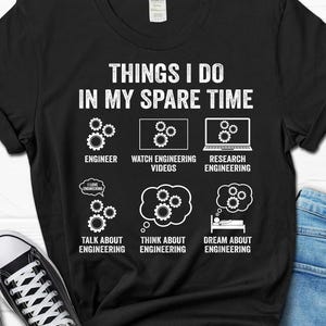 May include: Black t-shirt with white text that reads "Things I do in my spare time". The text is surrounded by icons of gears and thought bubbles. The icons represent activities related to engineering.
