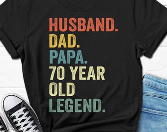 May include: Black t-shirt with a vintage-style graphic that reads "Husband. Dad. Papa. 70 Year Old Legend."