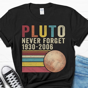 May include: Black t-shirt with a vintage-style graphic that says "Pluto Never Forget 1930-2006" and a stylized image of Pluto.