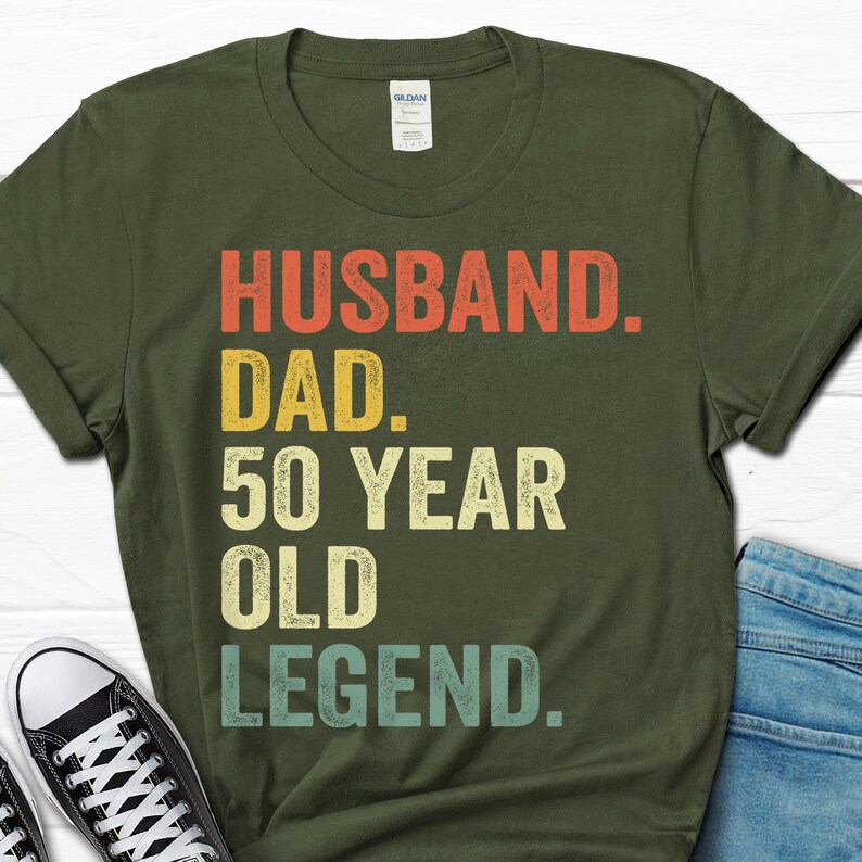 May include: A green t-shirt with the text "Husband. Dad. 50 Year Old Legend." in a vintage style font.