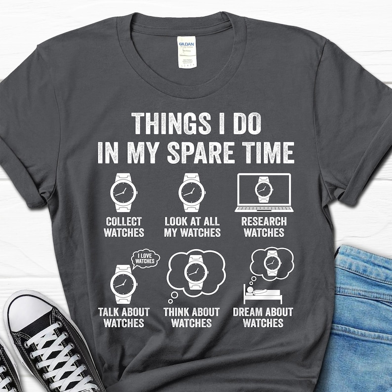 May include: Dark gray t-shirt with white text and watch graphics. The text reads "THINGS I DO IN MY SPARE TIME" with phrases like "Collect Watches" and "Dream About Watches". A fun gift for watch enthusiasts.