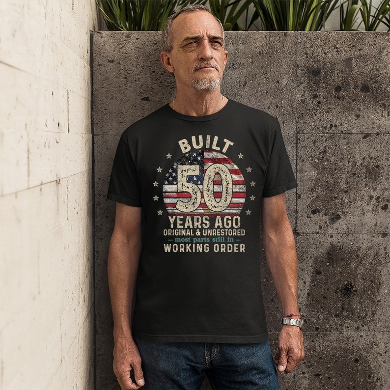 May include: A black t-shirt with a vintage American flag design and the text "BUILT 50 YEARS AGO ORIGINAL & UNRESTORED - most parts still in - WORKING ORDER".