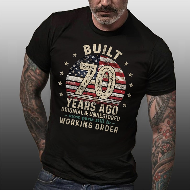 May include: Black t-shirt with a vintage American flag design and the text "BUILT 70 YEARS AGO ORIGINAL & UNRESTORED - most parts still in - WORKING ORDER".