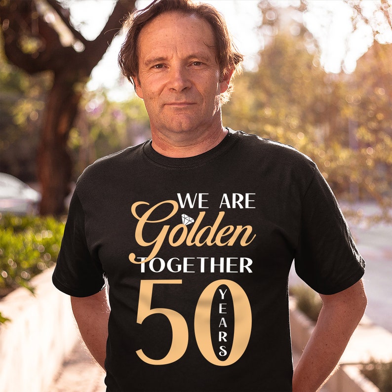 May include: A black t-shirt with the text "We are Golden Together 50 Years" in gold lettering. The number 50 is large and the word "Golden" has a diamond graphic.
