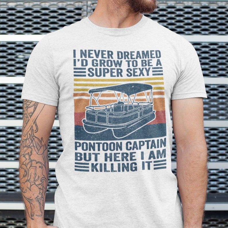 Pu&ograve; includere: Una maglietta bianca con una grafica in stile vintage di una barca pontone e il testo "Non avrei mai pensato di diventare un capitano di pontone super sexy, ma ecco, lo sto uccidendo."
