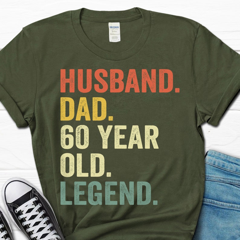 May include: A green t-shirt with the text "Husband. Dad. 60 Year Old. Legend." in a vintage style font.