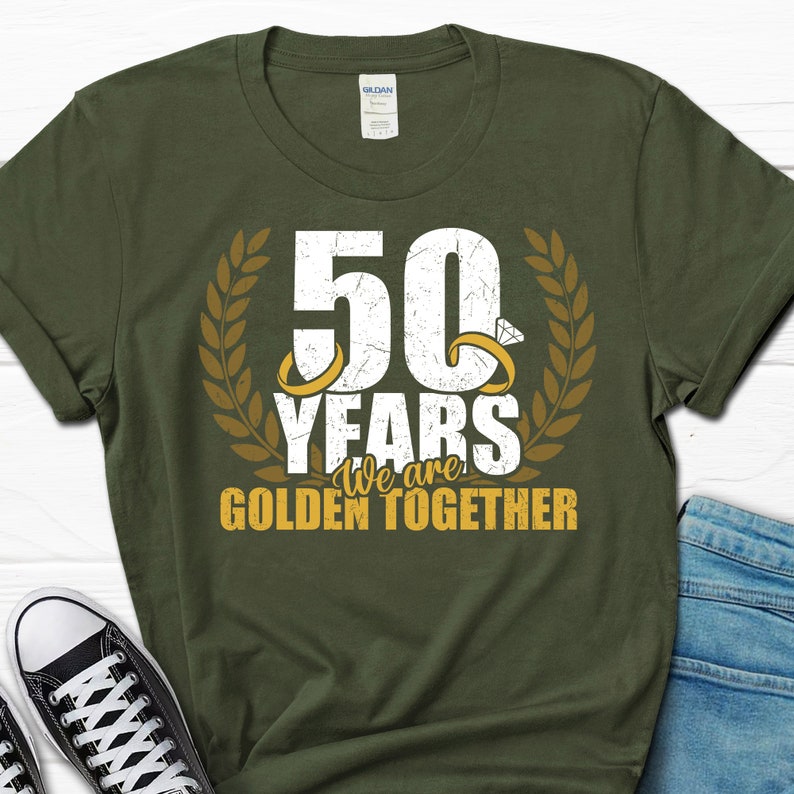 May include: Green t-shirt with a white graphic that says "50 Years We are Golden Together" with two gold rings and a diamond ring on the graphic.