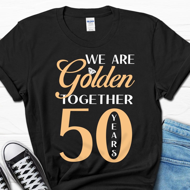 May include: Black t-shirt with the text "We are Golden Together 50 Years" in gold lettering. A diamond graphic is above the word "Golden".