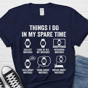 May include: Navy blue t-shirt with the text "THINGS I DO IN MY SPARE TIME" and watch-themed graphics. The graphics include watches and phrases like "Collect Watches" and "Dream About Watches".