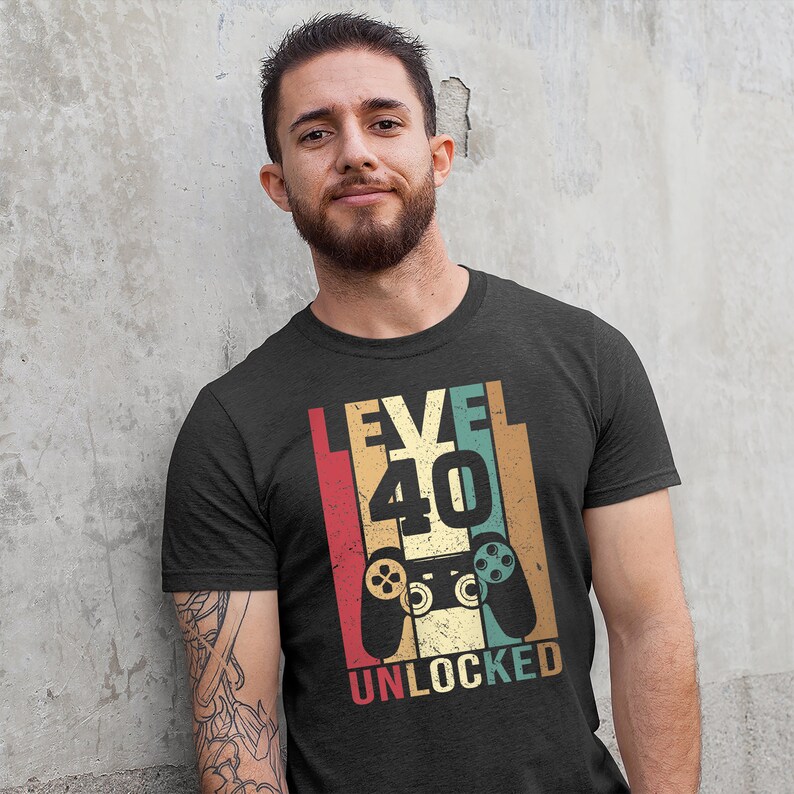 May include: A black t-shirt with a vintage-style graphic that says "Level 40 Unlocked" with a retro video game controller graphic.