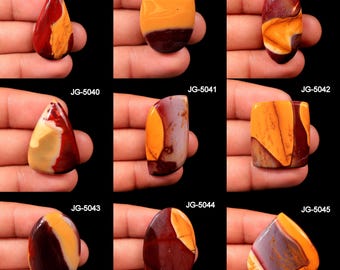 May include: A collection of nine polished gemstones in various shapes, including teardrop, oval, and rectangular. The stones feature a mix of colors, including shades of red, orange, and brown, with unique patterns and textures. Each stone is labeled with a unique identifier.