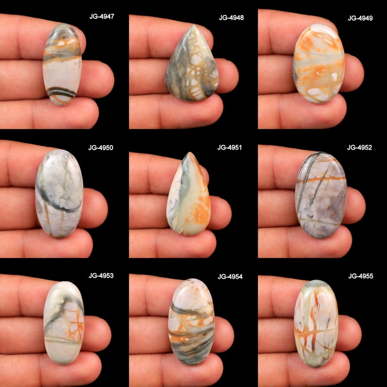 May include: A collection of nine polished cabochon gemstones in oval and teardrop shapes, each featuring unique natural patterns of gray, white, and orange veins. The stones are labeled JG-4947 through JG-4955, showcasing varied mineral inclusions.