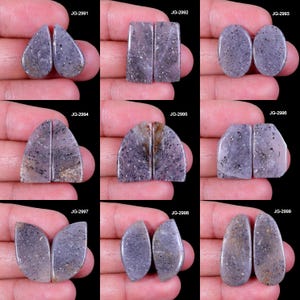 Puede incluir: Una colección de nueve pares de piedras preciosas pulidas de color lavanda. Cada par tiene una forma única, incluyendo diseños de lágrima, rectangulares, ovalados y arqueados. Las piedras tienen motas oscuras y se muestran sobre un fondo negro.