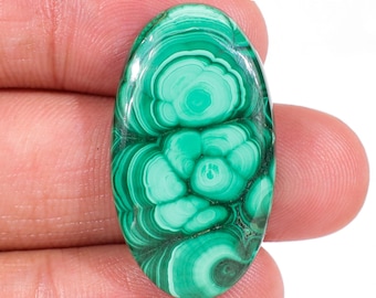 May include: An oval-shaped malachite gemstone featuring concentric bands of light and dark green patterns. The stone has a smooth, polished surface with a glossy finish. The text JG-9520 is visible in the upper right corner of the image.
