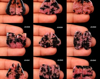Puede incluir: Colección de nueve pares de piedras preciosas pulidas, cada una con una forma y patrón únicos. Las piedras presentan una mezcla de tonos rosas y negros, con los textos "JG-6335" a "JG-6343" visibles en la imagen.