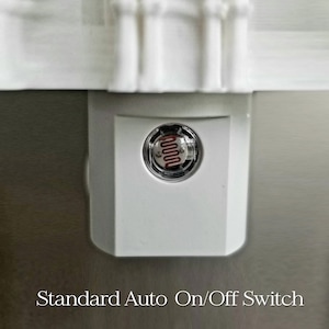 May include: A white night light with a Standard Auto On/Off Switch. The night light has a clear, circular sensor with a red, wavy filament. The night light is plugged into a wall outlet.