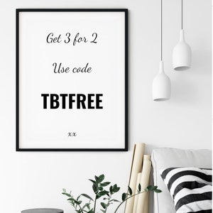 May include: A framed print with the text "Get 3 for 2", "Use code TBTFREE", and "xx". The print is in a black frame and hangs on a white wall. The image also shows two white pendant lights, a sofa with a striped pillow, and decorative items.