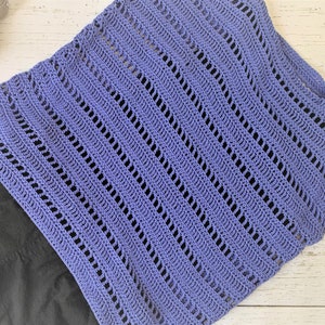 Puede incluir: Un top de ganchillo de color morado claro con un patr&oacute;n de encaje. El top est&aacute; hecho con un punto sencillo y tiene un ajuste holgado y fluido.