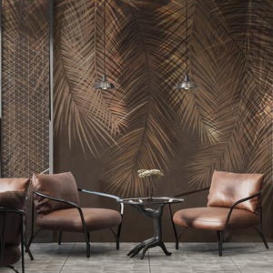 May include: An interior design scene featuring brown leather armchairs with black metal frames. The chairs are arranged in a room with a palm leaf wallpaper and hanging pendant lights. A small table with a unique base is in the center.