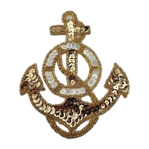 May include: A gold sequined anchor applique with white and brown accents. The nautical-themed patch features a detailed design with a cross at the top and a circular element in the center. The sequins are sewn onto a gold backing.