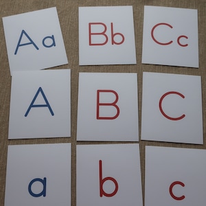 May include: Nine white cards with the letters A, a, B, b, C, c, A, B, and C printed on them. The letters A and a are in blue, and the letters B, b, C, and c are in red.