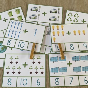 May include: A set of 10 printable math flash cards featuring images of wind turbines, solar panels, light bulbs, electric cars, and recycling symbols. Each card has an addition problem with the numbers 6, 7, 8, 9, 10, and 11. The cards are printed on white cardstock with green borders.