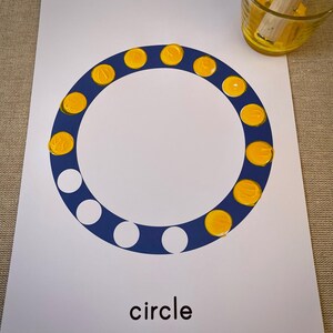 May include: A white sheet of paper with a blue circle outlined with yellow dots. The word "circle" is printed in black at the bottom of the page.