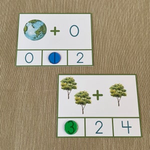 May include: Two math flash cards with a green and blue background. The first card shows a picture of the Earth and the equation 0 + 0 = 2. The second card shows a picture of three trees and the equation 3 + 2 = 4.