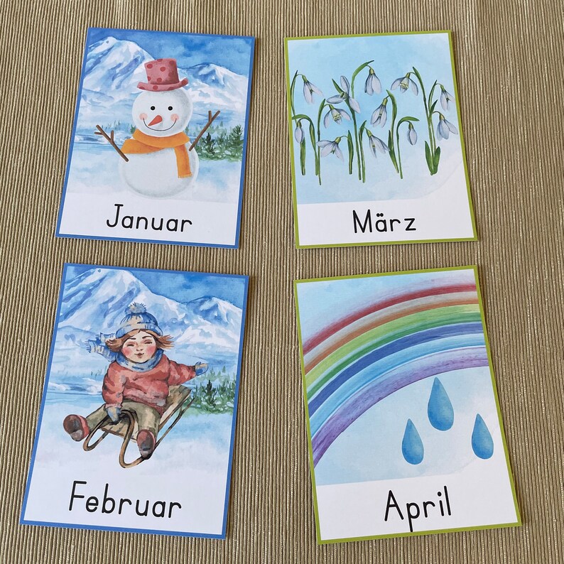 May include: Four illustrated cards depicting the months of January, February, March, and April. January shows a snowman, February shows a child sledding, March shows a field of snowdrops, and April shows a rainbow with raindrops.
