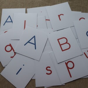 May include: A set of white alphabet flash cards with red and blue letters. The letters include A, B, g, i, p, r, and s.