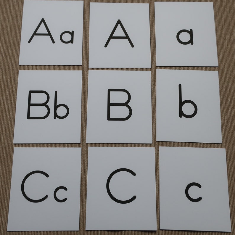 Peut inclure: Neuf cartes blanches avec des lettres majuscules et minuscules noires imprim&eacute;es dessus. Les lettres sont A, B et C.