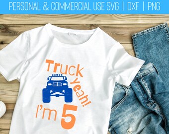 May include: A white t-shirt with a blue monster truck graphic and the text "Truck Yeah! I'm 5" in orange.