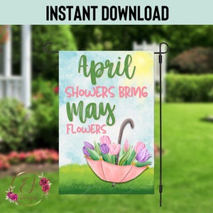 Puede incluir: Un paraguas rosa con hojas verdes y flores rosas en su interior. El paraguas está sobre un fondo de hierba verde con un cielo azul y nubes blancas. El texto "April Showers Bring May Flowers" está escrito en letras verdes y rosas.