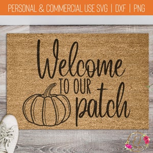 May include: A brown coir doormat with the text "Welcome to our patch" in black cursive font. A black line drawing of a pumpkin is to the left of the text.