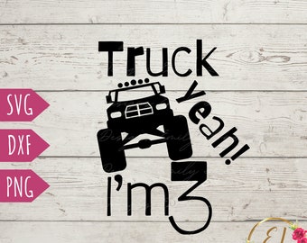 Op de afbeelding: Zwarte en witte silhouet van een monstertruck met de tekst "Truck Yeah! I'm 3" op een houten achtergrond.