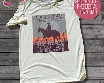 Op de afbeelding: Een sublimatieontwerp voor een T-shirt met een cowboy die op een paard rijdt met een zonsondergang op de achtergrond. De tekst luidt "Ik heb de wetten van de mens niet nodig om me te vertellen wat ik moet doen."