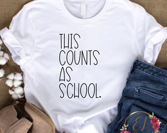 May include: White t-shirt with black text that reads "This counts as school."