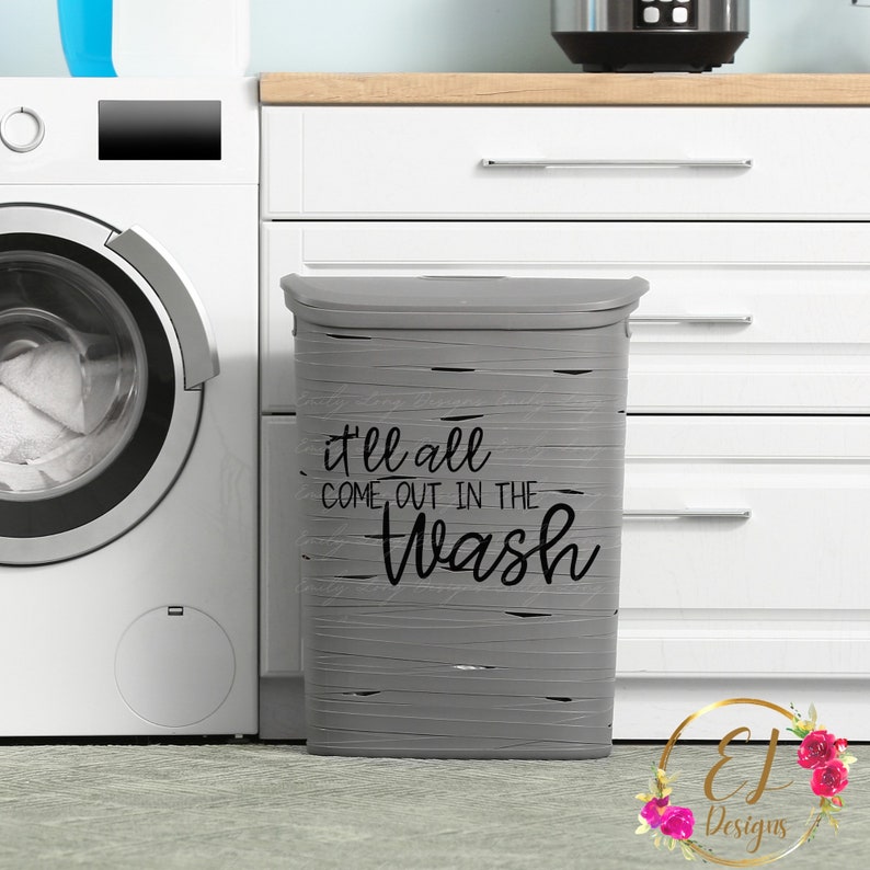 May include: A gray laundry hamper with a wood-grain pattern and the text "it'll all come out in the wash" in black lettering.