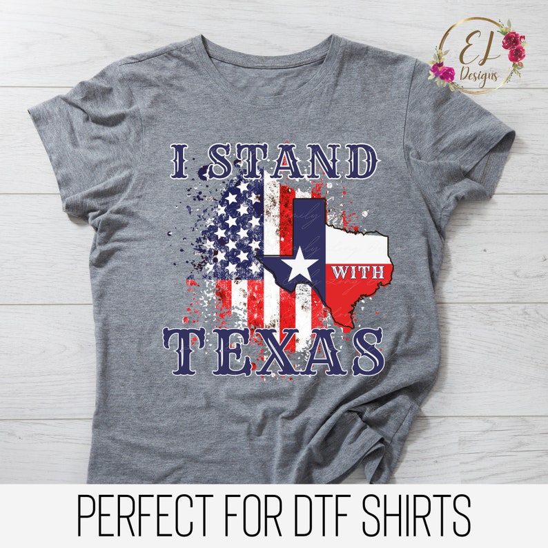 May include: Gray t-shirt with a distressed American flag and Texas outline. The text "I Stand With Texas" is printed on the shirt.