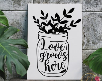 Op de afbeelding: Zwart-witte illustratie van een glazen pot met een boeket bloemen erin. De pot heeft de tekst "Love grows here" erop.