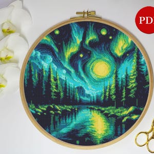May include: A cross-stitch pattern featuring a vibrant green and blue aurora borealis over a dark forest with a lake in the foreground. The pattern includes a bright yellow moon and stars.