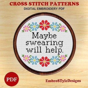 May include: A cross stitch pattern featuring a round embroidery hoop with a white background and the text "Maybe swearing will help." in black. The hoop is decorated with a border of colorful flowers.