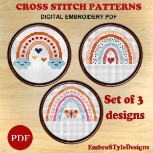 May include: Set of three rainbow cross stitch patterns in a digital embroidery PDF format. Each pattern features a rainbow with different details, including hearts, clouds, and a butterfly.