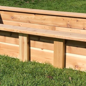 Puede incluir: Un lecho elevado de jard&iacute;n rectangular de madera de cedro. El lecho est&aacute; sobre un c&eacute;sped verde.