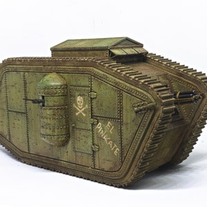 Puede incluir: Un tanque modelo verde y desgastado con una calavera y huesos cruzados pintados en el lateral. El tanque tiene una peque&ntilde;a torreta en la parte superior y las palabras "El Pinnacle" escritas en el lateral.
