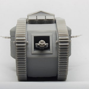 Puede incluir: Un modelo gris de un tanque de la Primera Guerra Mundial con un ca&ntilde;&oacute;n grande en la parte delantera y orugas en los lados.