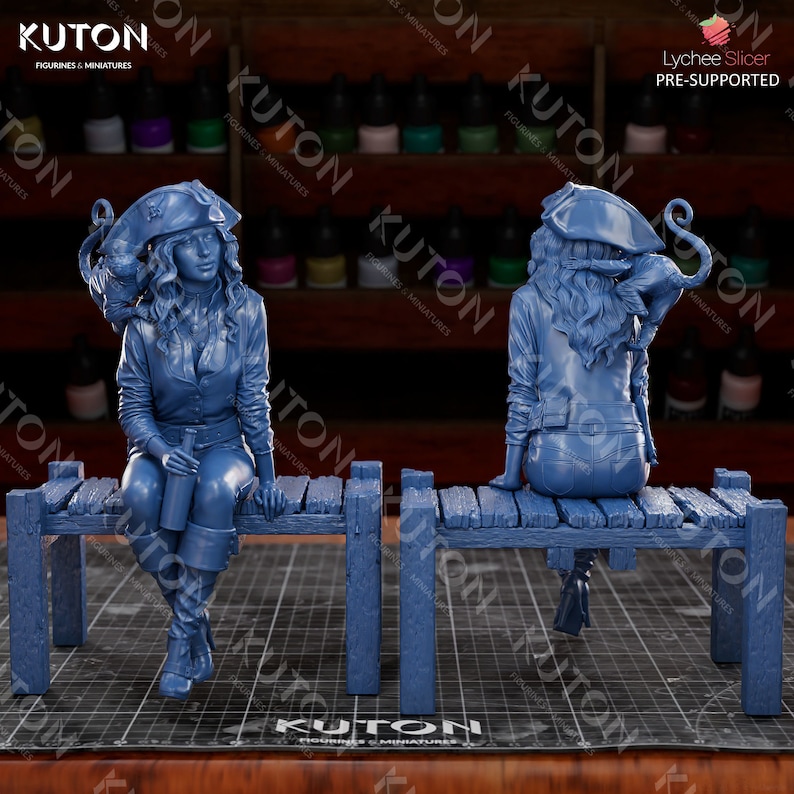 Pode incluir: Uma figura em miniatura de pirata feminina impressa em 3D de cor azul, sentada em um banco de madeira. A pirata est&aacute; vestindo uma jaqueta azul, cal&ccedil;as azuis e um chap&eacute;u de pirata. Ela est&aacute; segurando uma garrafa na m&atilde;o. A figura est&aacute; em pose com as pernas cruzadas e os bra&ccedil;os apoiados no banco. A figura &eacute; impressa em azul claro e tem um acabamento liso.